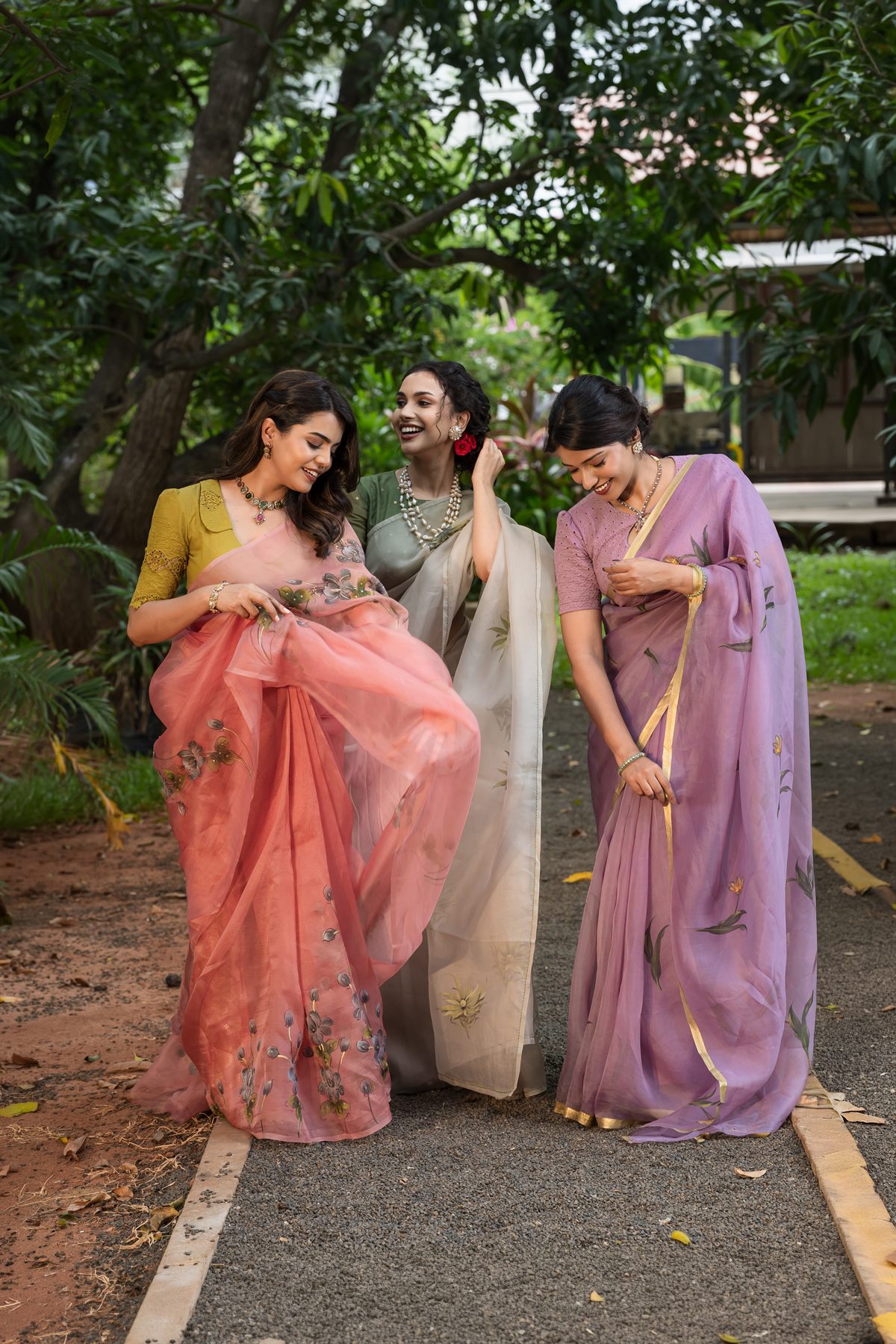 Three models in hand-painted pastel organza silk sarees